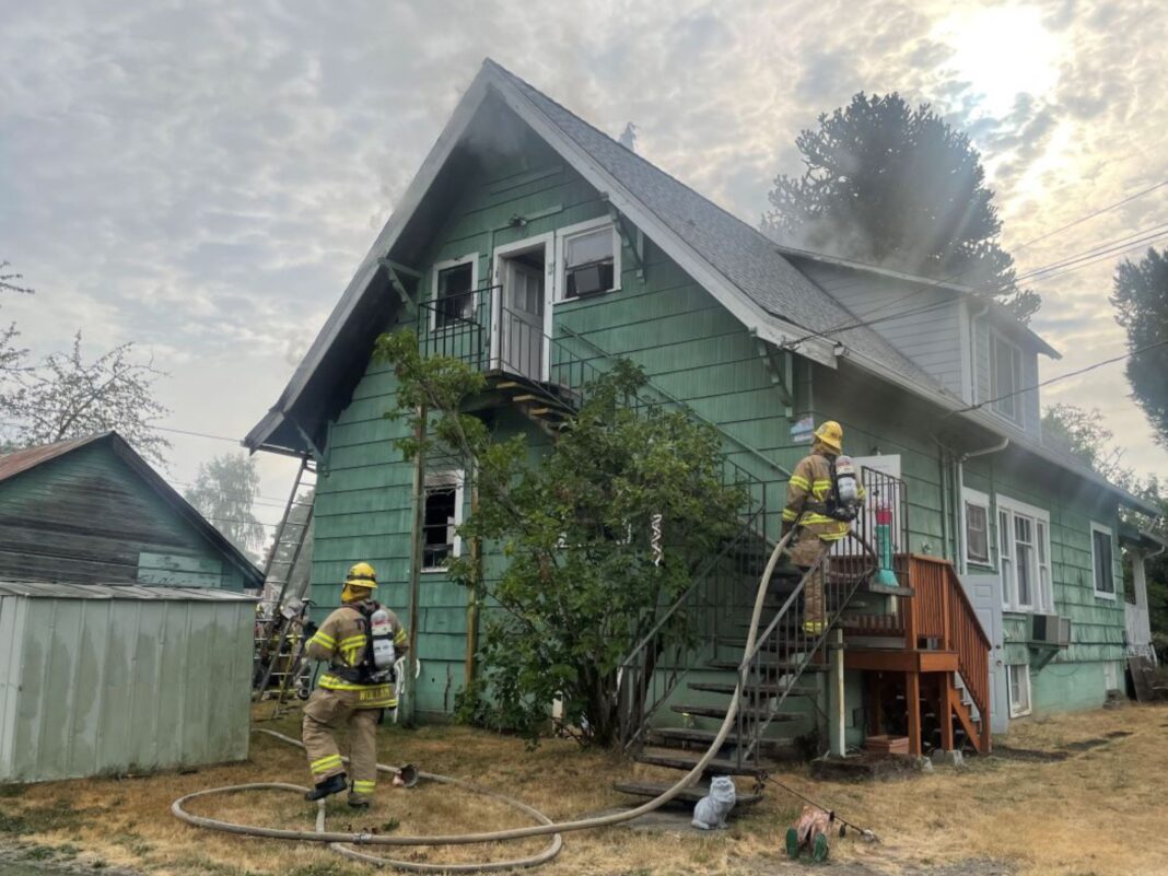 firefighters with hose side of triplex in sherwood