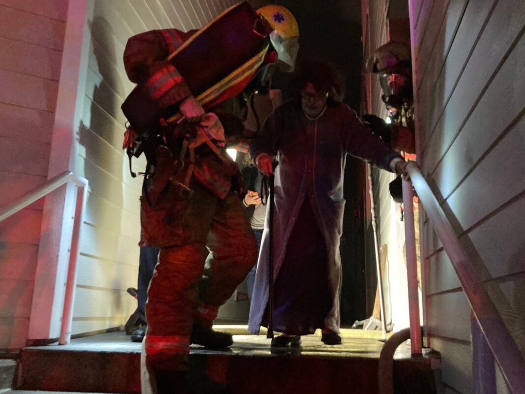 firefighters helping a resident out of thier home
